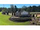 Stone monument sign at Wildwood Place, surrounded by lush landscaping and manicured lawns at 4529 Twinberry Dr, Powder Springs, GA 30127