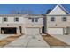 Exterior view of a townhouse featuring a brick facade and attached garages at 4529 Twinberry Dr, Powder Springs, GA 30127