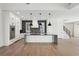 A spacious white kitchen with modern appliances, dark stone countertops, and three pendant lights above the island at 120 Thome Dr, Alpharetta, GA 30022