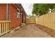 Fenced-in backyard with a red brick home and a small deck with wooden railings at 2216 Golden Dawn Sw Dr, Atlanta, GA 30311