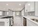 Spacious kitchen with white cabinets, stainless steel appliances, quartz counters, and seamless flow to the living area at 2216 Golden Dawn Sw Dr, Atlanta, GA 30311