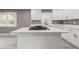 Bright kitchen features white cabinetry, an island with range, quartz countertops, and modern black hardware at 2216 Golden Dawn Sw Dr, Atlanta, GA 30311