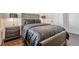Bedroom with gray upholstered bed, wood floors and dark gray accents at 104 Ivey Way, Woodstock, GA 30188