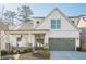 Charming two-story home with landscaped yard, gray garage door, and covered front porch at 104 Ivey Way, Woodstock, GA 30188