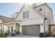 Stylish exterior featuring light siding, a gray garage door and a landscaped front yard at 104 Ivey Way, Woodstock, GA 30188