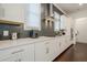 Modern kitchen featuring white cabinets, grey backsplash, and stainless steel appliances at 104 Ivey Way, Woodstock, GA 30188