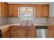 Well-lit kitchen with wood cabinets and modern stainless dishwasher at 85 Blue Jay Dr, Covington, GA 30016