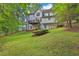 A landscaped backyard, with a fire pit, a deck, and wooded perimeter at 625 Piping Rock Pt, Lawrenceville, GA 30043