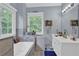 Bright bathroom featuring double vanity and large mirrors, bathed in natural light from two windows at 625 Piping Rock Pt, Lawrenceville, GA 30043