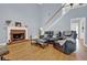 Spacious living room featuring a brick fireplace, hardwood floors, and staircase at 625 Piping Rock Pt, Lawrenceville, GA 30043