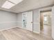 A basement with gray walls, wood look floors and two open doorways to another room and a bathroom at 2170 Charleston Pl, Lithia Springs, GA 30122