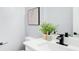 Modern bathroom features a white countertop, black faucet, and minimalist decor with a stylish house plant at 2170 Charleston Pl, Lithia Springs, GA 30122