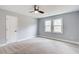 A well-lit bedroom featuring plush carpeting, double windows, and a ceiling fan for added comfort at 2170 Charleston Pl, Lithia Springs, GA 30122