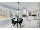 Bright dining area adjacent to a modern kitchen, featuring white trim and large windows at 2170 Charleston Pl, Lithia Springs, GA 30122