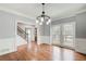 Elegant dining room featuring hardwood floors, wainscoting and modern chandelier at 2170 Charleston Pl, Lithia Springs, GA 30122