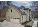 Two-story home with a two-car garage, green siding, and a dark roof at 2170 Charleston Pl, Lithia Springs, GA 30122