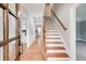 Welcoming foyer with hardwood floors, staircase with wooden handrail, and views into the kitchen at 2170 Charleston Pl, Lithia Springs, GA 30122