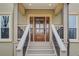 Elegant home entrance featuring a wooden door, stairs, and a well-maintained porch at 2170 Charleston Pl, Lithia Springs, GA 30122