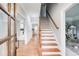 Hallway with wooden floors, staircase and wood-framed glass doors at 2170 Charleston Pl, Lithia Springs, GA 30122