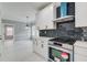 Modern kitchen with white cabinets, stainless steel appliances, and dark backsplash at 2170 Charleston Pl, Lithia Springs, GA 30122