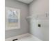 Simple laundry room with tile floors, a window for natural light, and white wire shelving at 2170 Charleston Pl, Lithia Springs, GA 30122