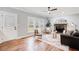 Bright living room featuring hardwood floors, stone fireplace, modern fan, and ample natural light at 2170 Charleston Pl, Lithia Springs, GA 30122