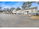 Exterior view of the unit featuring a parking lot with multiple parking spaces and a charming gray picket fence at 257 Country Club Dr, Jonesboro, GA 30238