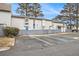 Exterior view of the unit featuring a parking lot with multiple parking spaces and a charming gray picket fence at 257 Country Club Dr, Jonesboro, GA 30238