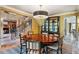 Formal dining area with a round wood table, yellow walls and a wrought iron staircase in the background at 1125 Lake Shore Overlook, Alpharetta, GA 30005