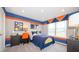 Bright bedroom with blue and orange accents, carpet, and windows at 146 Oakchase Park Ln, Hampton, GA 30228