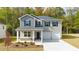 Two-story home with light gray siding, a dark gray roof, and a two car garage at 146 Oakchase Park Ln, Hampton, GA 30228