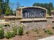 Stone sign welcomes you to Oakchase at Hampton with brick accents and pretty white flowers at 146 Oakchase Park Ln, Hampton, GA 30228