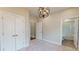 Neutral bedroom featuring carpeted floor, an iron chandelier, and white double door closet for ample storage at 324 Concord St, Alpharetta, GA 30009