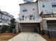 The attached garage of this townhome has a private balcony and brick support columns at 324 Concord St, Alpharetta, GA 30009