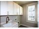 This laundry room features white cabinets, quartz countertop, and a bronze faucet and hardware at 324 Concord St, Alpharetta, GA 30009