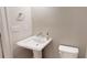 Powder room featuring a pedestal sink, modern fixtures, and stylish hand soap dispenser at 324 Concord St, Alpharetta, GA 30009