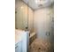 Walk-in shower featuring modern fixtures, a bench, and stone flooring at 324 Concord St, Alpharetta, GA 30009