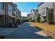 A picturesque street view with brick pavers leads to modern townhomes with lush landscaping at 324 Concord St, Alpharetta, GA 30009