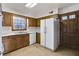 Bright kitchen features wood cabinets, white appliances, and a view to the backyard at 1892 Mercedes Ne Ct, Atlanta, GA 30345