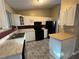 Galley kitchen with white cabinets, black appliances, and tile floor at 3959 Wood Path Dr, Stone Mountain, GA 30083