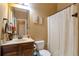 Cozy bathroom featuring a shower with curtain, commode, vanity with mirror, and decor at 200 Claret Way, Mcdonough, GA 30252