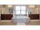 Bright bathroom features a soaking tub, tile surround, and and vanities at 200 Claret Way, Mcdonough, GA 30252