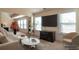 Bright living room features a large-screen TV, neutral tones, two windows, and modern decor at 200 Claret Way, Mcdonough, GA 30252