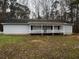 Exterior of home showing light gray siding, covered porch and established lawn at 2755 Berry Rd, Loganville, GA 30052