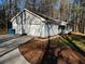 View of light gray house with 2-car garage, porch, and nice yard and landscaping at 2755 Berry Rd, Loganville, GA 30052
