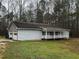 Exterior elevation of light gray house with 2-car garage and covered front porch at 2755 Berry Rd, Loganville, GA 30052