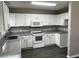 Galley kitchen with white cabinets, granite countertops and stainless appliances at 2755 Berry Rd, Loganville, GA 30052