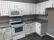Galley kitchen with white cabinets, granite countertops and stainless appliances at 2755 Berry Rd, Loganville, GA 30052