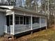 Close up of covered front porch with white rails and lattice detail at 2755 Berry Rd, Loganville, GA 30052