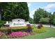 Community sign for Highcroft, showcasing lush landscaping and flowering plants at 3820 Mast Nw Ct, Kennesaw, GA 30144